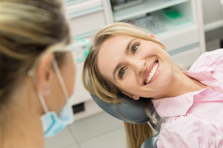 lady with white teeth smiling in dental chair